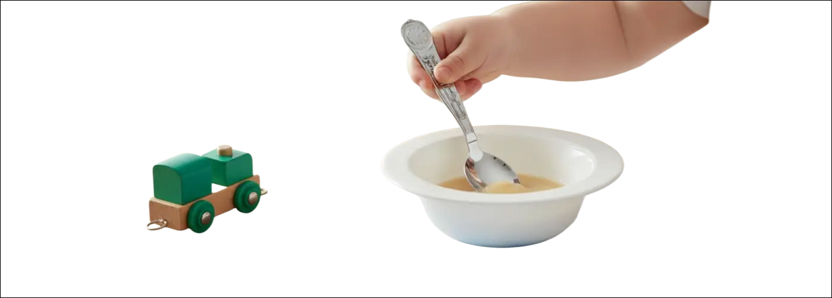 Mano di bambino con cucchiaio argento Trenino Zaramella Argenti su ciotola bianca