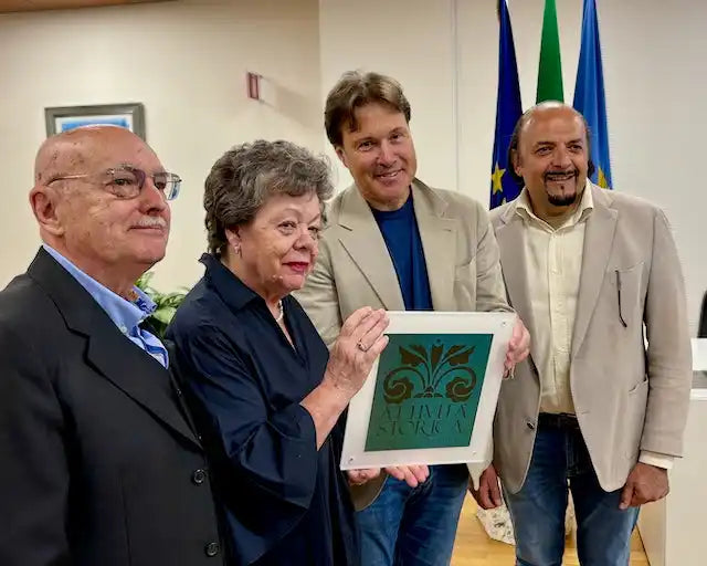 Una placca verde incorniciata con un disegno intricato.