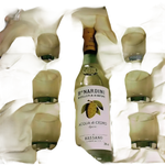 Bottiglia di liquore chiaro con etichetta agrumi e sei bicchieri frostati in scatola